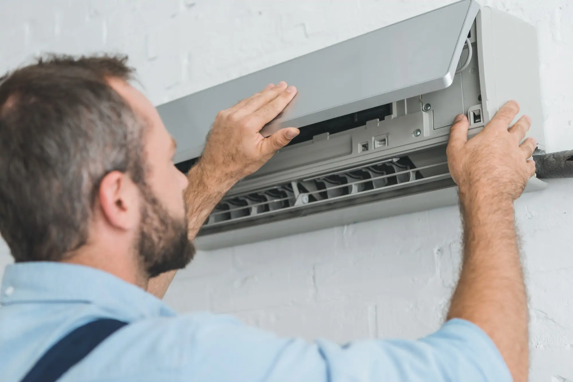 male worker fixing air conditioner at home.jpg